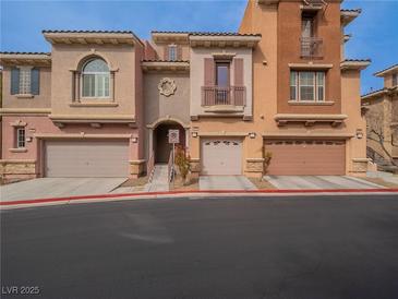 View of the townhome-style condos featuring multiple-car garages and a well-maintained exterior at 10051 Sand Key St, Las Vegas, NV 89178