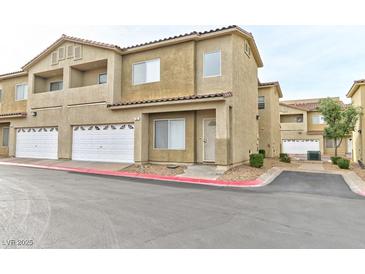 Inviting two-story townhouse featuring attached garage, balcony, and manicured landscaping at 53 Blue Beak Way, Henderson, NV 89012