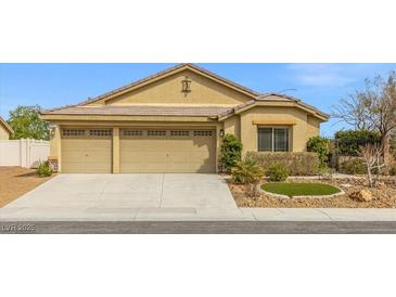 Inviting single-story home featuring a three-car garage and low maintenance desert landscaping at 5912 Cuddles Ct, North Las Vegas, NV 89081