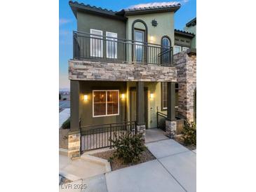 Two-story townhome featuring stone accents, a balcony, and a covered front porch at 6447 Wide Sky St, Las Vegas, NV 89166