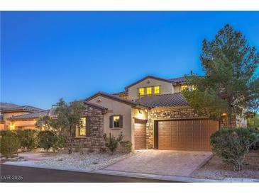 Charming home featuring a stone facade, tile roof, attached two-car garage, and well-manicured landscaping at 79 Rezzonico Dr, Henderson, NV 89011