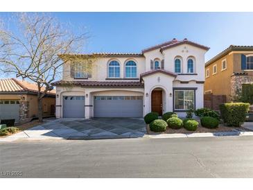 Charming two-story home with arched windows, a three-car garage, and manicured landscaping at 8743 Mount Mira Loma Ave, Las Vegas, NV 89178