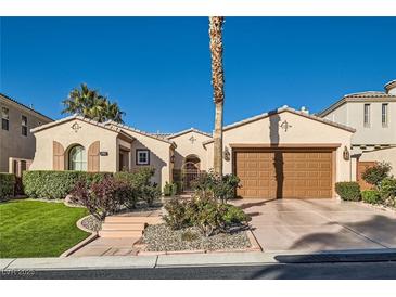 Charming single-story home with desert landscaping, mature palm tree, and a two-car garage at 11569 Snow Creek Ave, Las Vegas, NV 89135