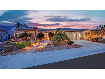 Stunning single-story home featuring beautiful desert landscaping with walkway and well-lit exterior at dusk at 2167 Fairweather St, Henderson, NV 89052
