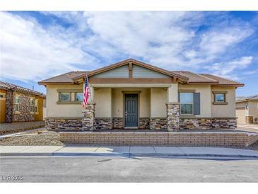 Charming single-story home featuring a covered front porch with stone accents and a well-manicured lawn at 762 Lilac Oak St, Henderson, NV 89011
