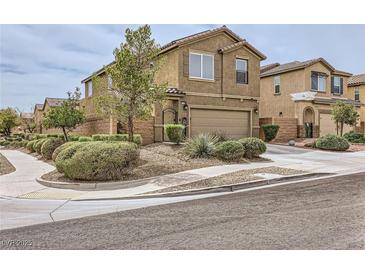 Charming two-story home with brown stucco, complemented by well-maintained landscaping and a two-car garage at 117 Blue Trout Ave, Henderson, NV 89011
