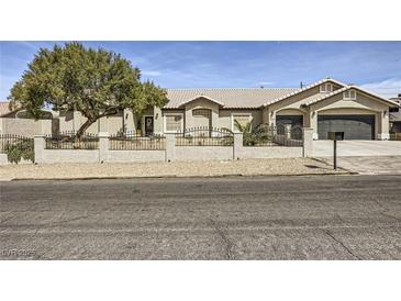 Charming single-story home with a tile roof, an iron fence, a gravel yard, and an attached two-car garage at 1630 Sundown Dr, Henderson, NV 89002