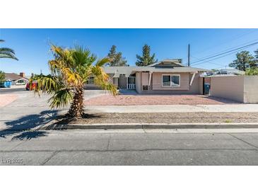 Charming single-story home with desert landscaping, secure gate, and a quaint covered entrance at 1900 E Oakey Blvd, Las Vegas, NV 89104