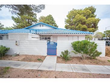 Charming single-story home featuring a blue-tiled roof, private courtyard, and mature trees at 2121 Twickenham Pl # D, Las Vegas, NV 89108