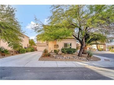 Charming home featuring a desert landscape and mature trees in a well-maintained front yard at 2293 Bull Lake Dr, Henderson, NV 89052