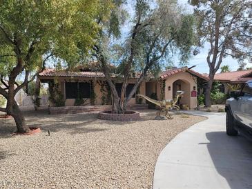 Charming single-story home with mature trees, desert landscaping, and unique dinosaur lawn ornament at 3132 El Camino Rd, Las Vegas, NV 89146