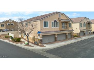 Inviting multi-level townhome showcases a stucco facade, a private balcony, and a three-car garage at 3405 Robust Robin Pl # 3, North Las Vegas, NV 89084