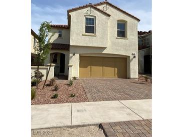 Two-story home featuring a two-car garage, desert landscaping, and a classic stucco facade at 346 Andy Wheeler Dr, Henderson, NV 89011