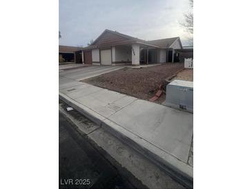 Traditional single-story home featuring a two-car garage and a covered carport at 4868 Treetrunk Ave, Las Vegas, NV 89147