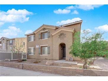 Charming two-story home with tan stucco, low brick wall and an arched entry at 963 Sable Chase Pl, Henderson, NV 89011