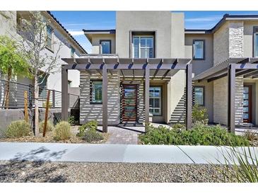 Contemporary two-story home with a decorative pergola, stone accents, and stylish front yard landscaping at 11705 Bearpaw Meadow Ave, Las Vegas, NV 89138