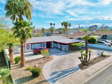 Charming single-story home with a circular driveway, desert landscaping, and mature palm trees at 1589 Silver Mesa Way, Las Vegas, NV 89169