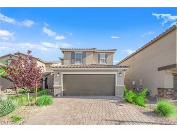 Charming two-story home with a two-car garage, tiled roof, brick driveway and fresh landscaping at 1606 Wild Grain Ave, North Las Vegas, NV 89086