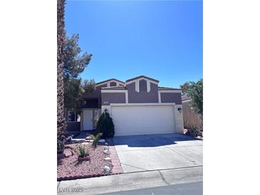 Two-story home with a two car garage and landscaped front yard under a clear blue sky at 1655 Morse Arberry Ave, Las Vegas, NV 89106