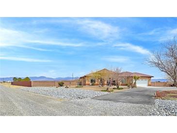 Spacious desert home featuring rock landscaping, ample parking, and mountain views at 1830 E Fuchsia St, Pahrump, NV 89048