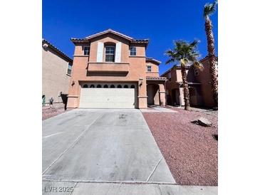 Two story home features tan stucco, two car garage, neutral trim, and desert landscaping at 2316 Cockatoo Dr, North Las Vegas, NV 89084