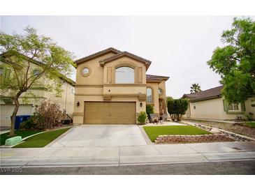 Two-story home featuring a two-car garage, arched windows and manicured lawn at 3916 Broad Meadow Ct, Las Vegas, NV 89129