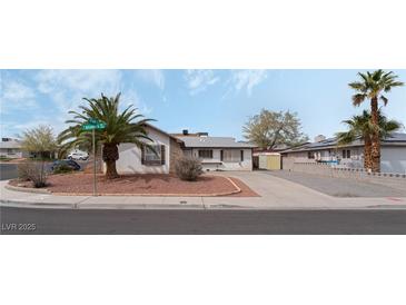 Charming single-story home featuring desert landscaping, a long driveway, and palm trees at 420 Altamira Rd, Las Vegas, NV 89145