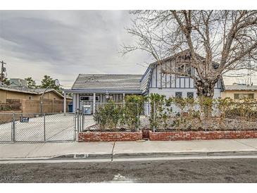 Charming home with a fenced yard, mature tree, and classic architectural details under a cloudy sky at 5129 Del Monte Ave, Las Vegas, NV 89146