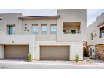 Contemporary townhouse featuring private two-car garage and a second-story balcony at 600 N Carriage Hill Dr # 2174, Las Vegas, NV 89138
