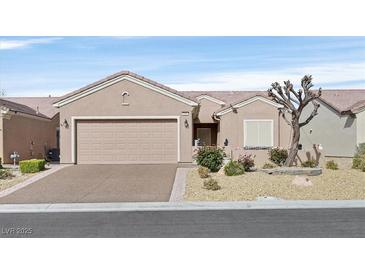 Charming single-story home featuring a two-car garage, desert landscaping, and a welcoming facade at 7741 Fruit Dove St, North Las Vegas, NV 89084