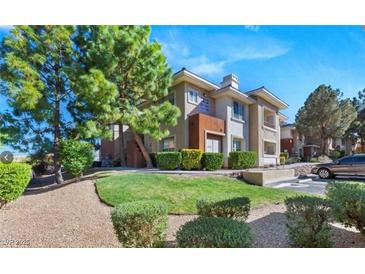 Inviting condo showcases mature trees, green lawn, assigned parking, and well-maintained landscaping at 1012 Domnus Ln # 105, Las Vegas, NV 89144