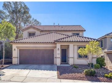 Charming two-story home featuring a tile roof, well-manicured landscaping, and a two-car garage, creating curb appeal at 1077 Lemongrass Ct, Henderson, NV 89002