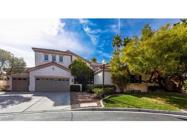 Beautiful two-story home featuring a three car garage, landscaped front yard, and a red tile roof at 1301 Kingdom St, Las Vegas, NV 89117