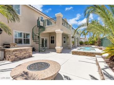 Outdoor patio features a fire pit, outdoor kitchen, and a second-story balcony with spiral staircase at 3088 Via Flaminia Ct, Henderson, NV 89052
