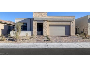 Beautiful single-story home with stone accents, neutral color palette, desert landscaping and brick paved driveway at 5030 Sandline Court, Las Vegas, NV 89135