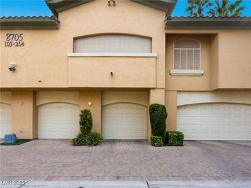 Multi-car garage with well-maintained landscaping in a modern designed home with neutral color palette at 8705 Red Brook Dr # 203, Las Vegas, NV 89128