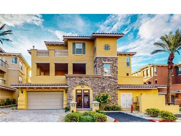 Elegant home showcases a stone facade, private balcony, and a two-car garage with ample parking at 25 Luce Del Sole # 3, Henderson, NV 89011