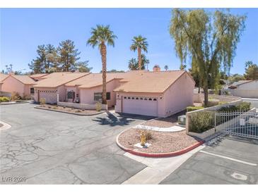 Inviting single-story home featuring desert landscaping, a tile roof, and a two-car garage at 2699 Aldonza Dr, Henderson, NV 89014