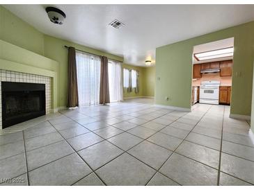 Spacious living room featuring tile floors, a fireplace, and access to the kitchen space at 6250 W Flamingo Rd # 135, Las Vegas, NV 89103