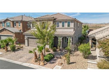 Charming two-story home featuring a tile roof, desert landscaping, and a welcoming covered entryway at 7837 Hamilton Pool Dr, Las Vegas, NV 89113