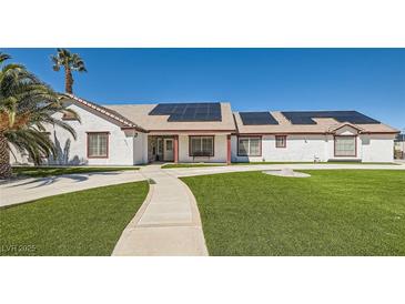 Charming single story home features a lush green lawn, solar panels, and desert landscaping at 8515 Belcastro St, Las Vegas, NV 89113