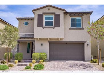 Charming two-story home with stucco facade, stone accents, a two-car garage, and professionally landscaped front yard at 8564 Scalpay St, Las Vegas, NV 89166