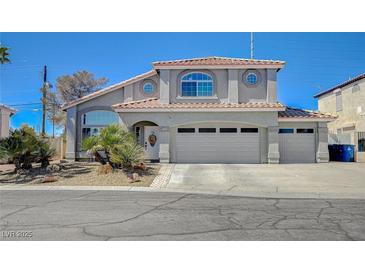 Charming two-story home with well-maintained landscaping, arched entry, and a three-car garage at 8725 Hawk Canyon St, Henderson, NV 89074