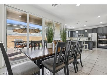 Open concept dining room featuring a dark wooden table and views of the backyard patio at 160 Lilt Ave, Henderson, NV 89011