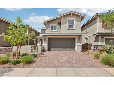 Two story home featuring a brick driveway, two car garage, and manicured landscaping at 160 Lilt Ave, Henderson, NV 89011