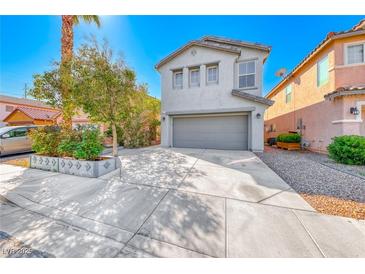 Two-story home featuring a gray painted facade, attached two car garage, and low maintenance landscaping at 4921 Lazy Day Ct, Las Vegas, NV 89131