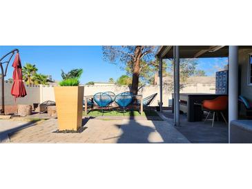 Landscaped backyard featuring an outdoor dining area, mature trees, and a patio at 5318 Palmyra Ave, Las Vegas, NV 89146