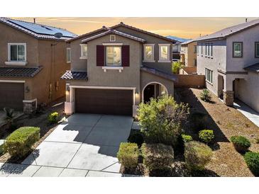 Two-story home with a two-car garage, neutral color scheme, and well-manicured landscaping at 6403 Dundock Ave, Las Vegas, NV 89122