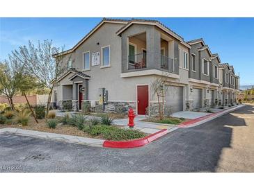 Attractive townhome exterior featuring a private balcony, well-kept landscaping, and a red fire hydrant on the street at 7204 N Decatur Blvd, North Las Vegas, NV 89131