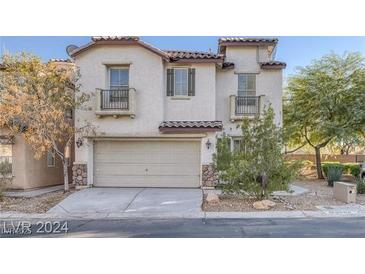Two-story home with a neutral facade, balcony, and a two-car garage at 5081 Pine Mountain Ave, Las Vegas, NV 89139